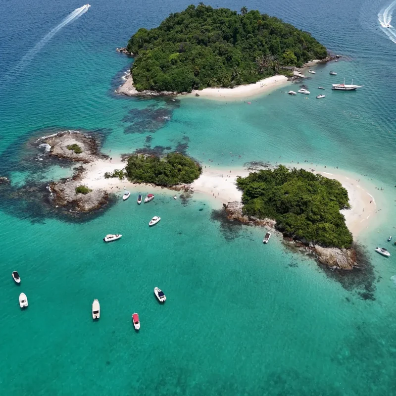 Vista aérea da Ilha de Cataguás, com lanchas e escunas fundeadas em seu entorno.